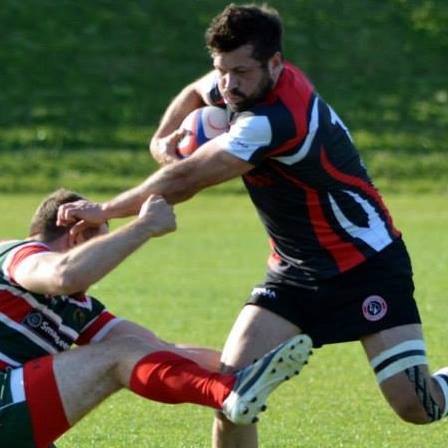 amateur rugby player handing off a tackle