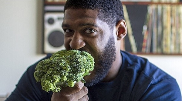 picture of david carter ex NFL player eating raw broccoli 