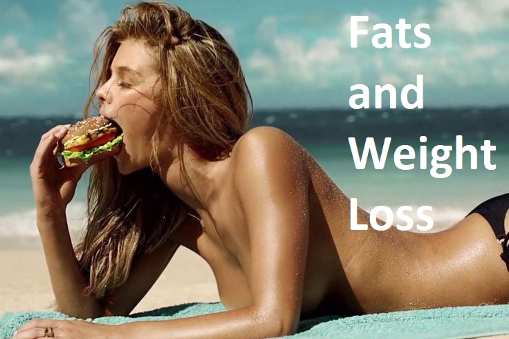 female model eating hamburger on the beach