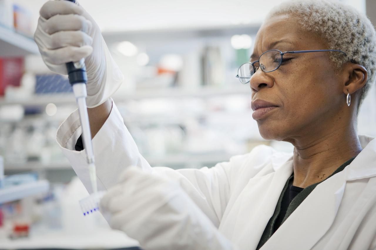 black female scientist using a pipette