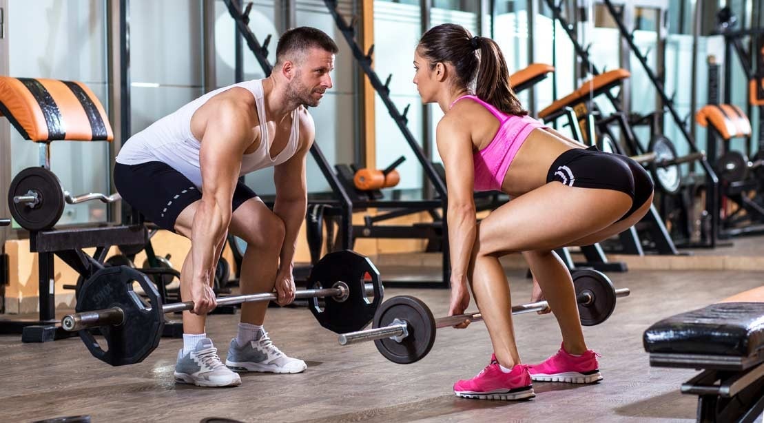man and woman in a gym doing deadlifts together 